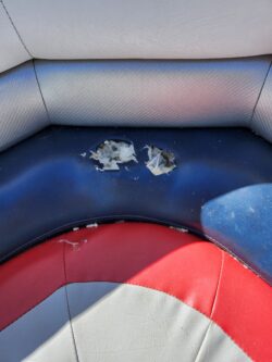 Damaged blue and white marine vinyl boat seat before repair