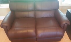 Brown leather loveseat after professional restoration